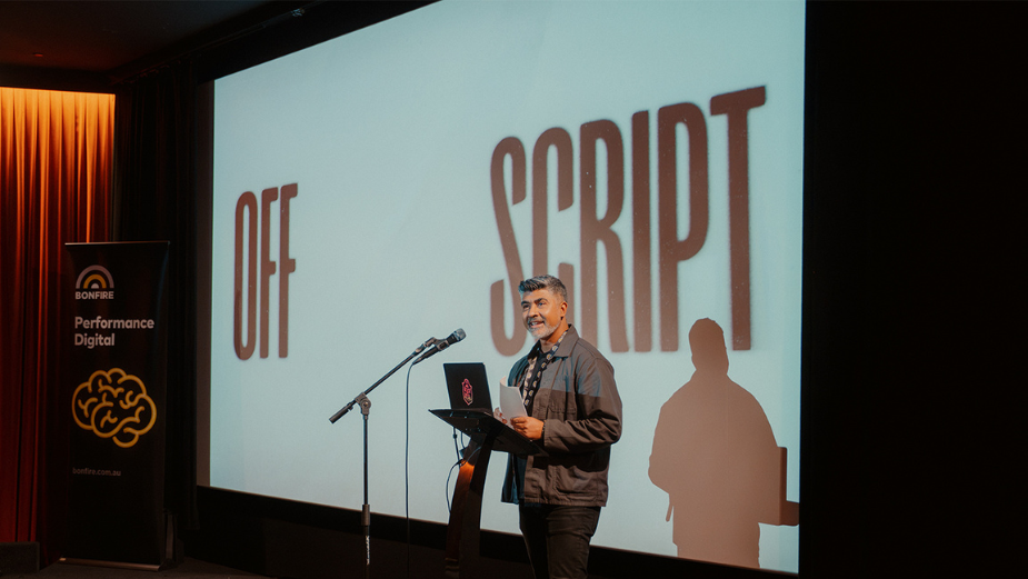 Luke Williams presenting at Off Script, with the title on the cinema screen