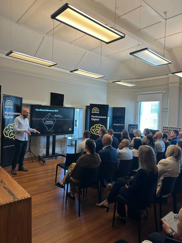 A photo of Matthew Elshaw presenting to a room of marketing professionals and business owners about AI Search Reporting.